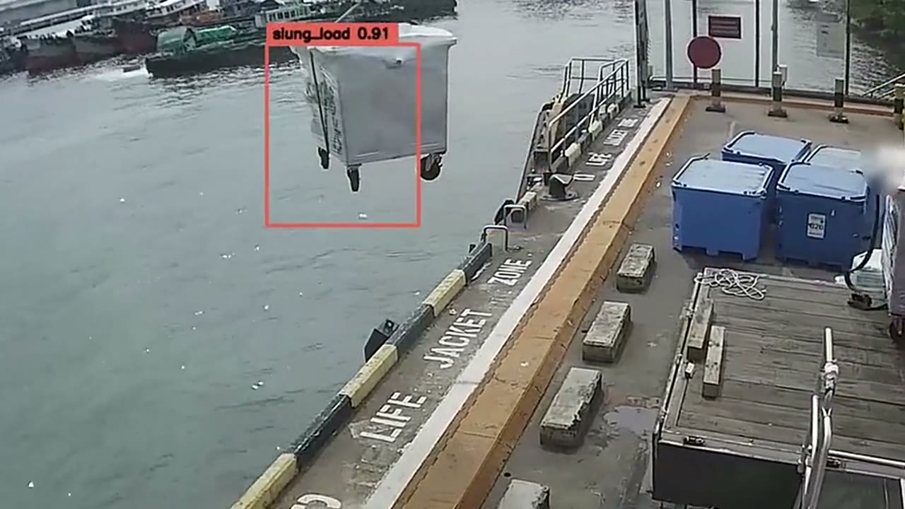A slung load lifted on a wharf, watched for people in the lift zone