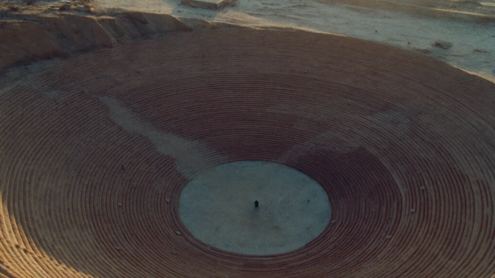 Aerial view of a circular terraced excavation at dawn
