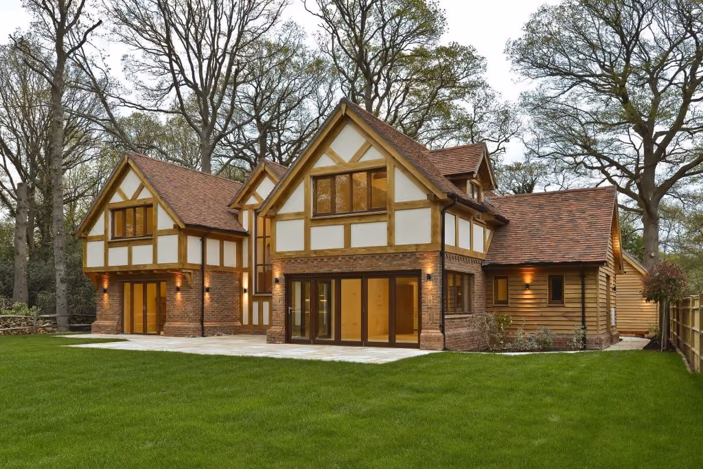 A large country home at dusk with warm lights on