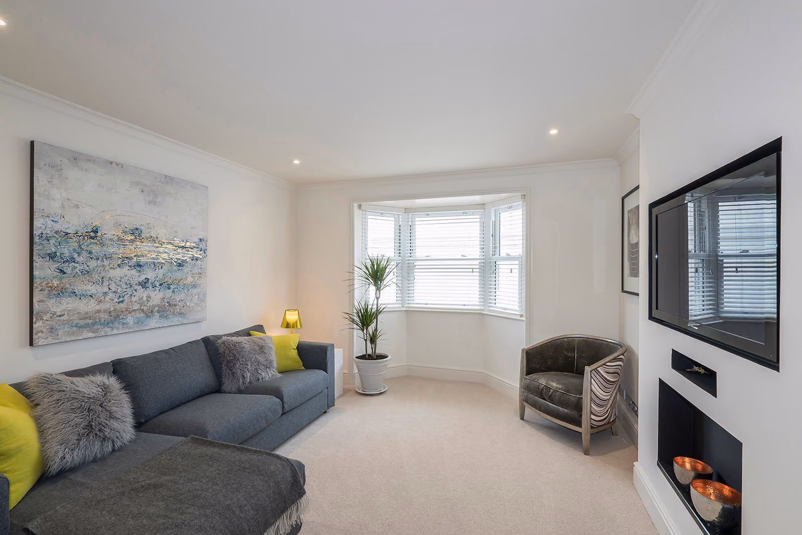 A premium apartment living room with a grey sofa and clean white walls