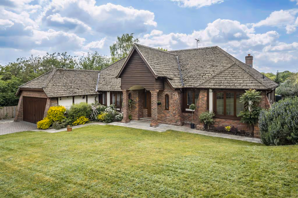 A country home with large driveway big garden on a sunny day
