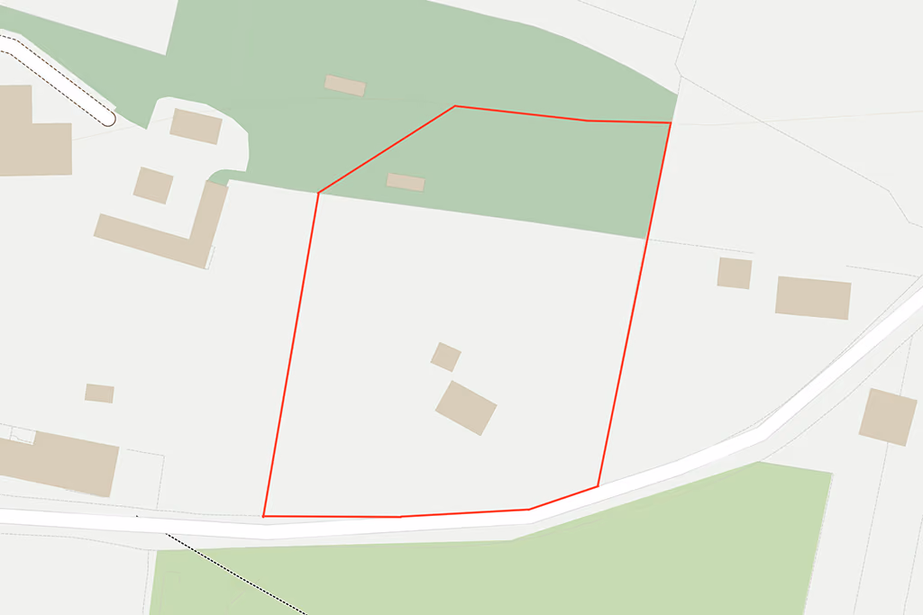 Map showing land outlined in red with several buildings and surrounding green areas.