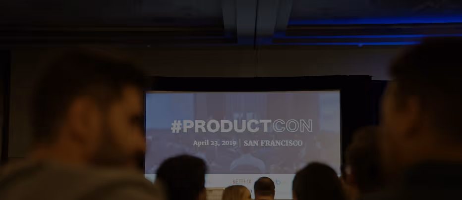 Audience watching a presentation with a screen reading #PRODUCTCON April 23, 2019 San Francisco.