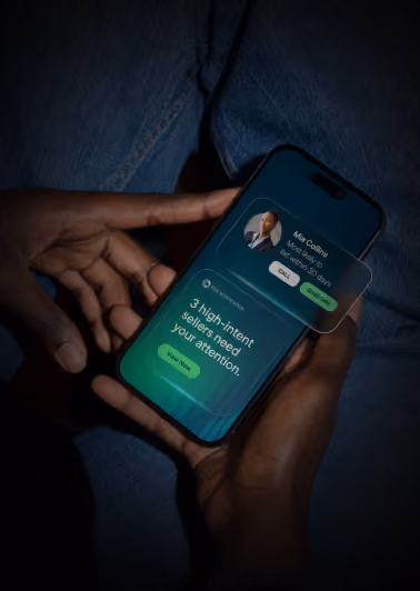 Hands holding a smartphone displaying a screen with a message reading '3 high-intent sellers need your attention' and a notification window showing a contact named Mia Coyne with options to call or start chat.