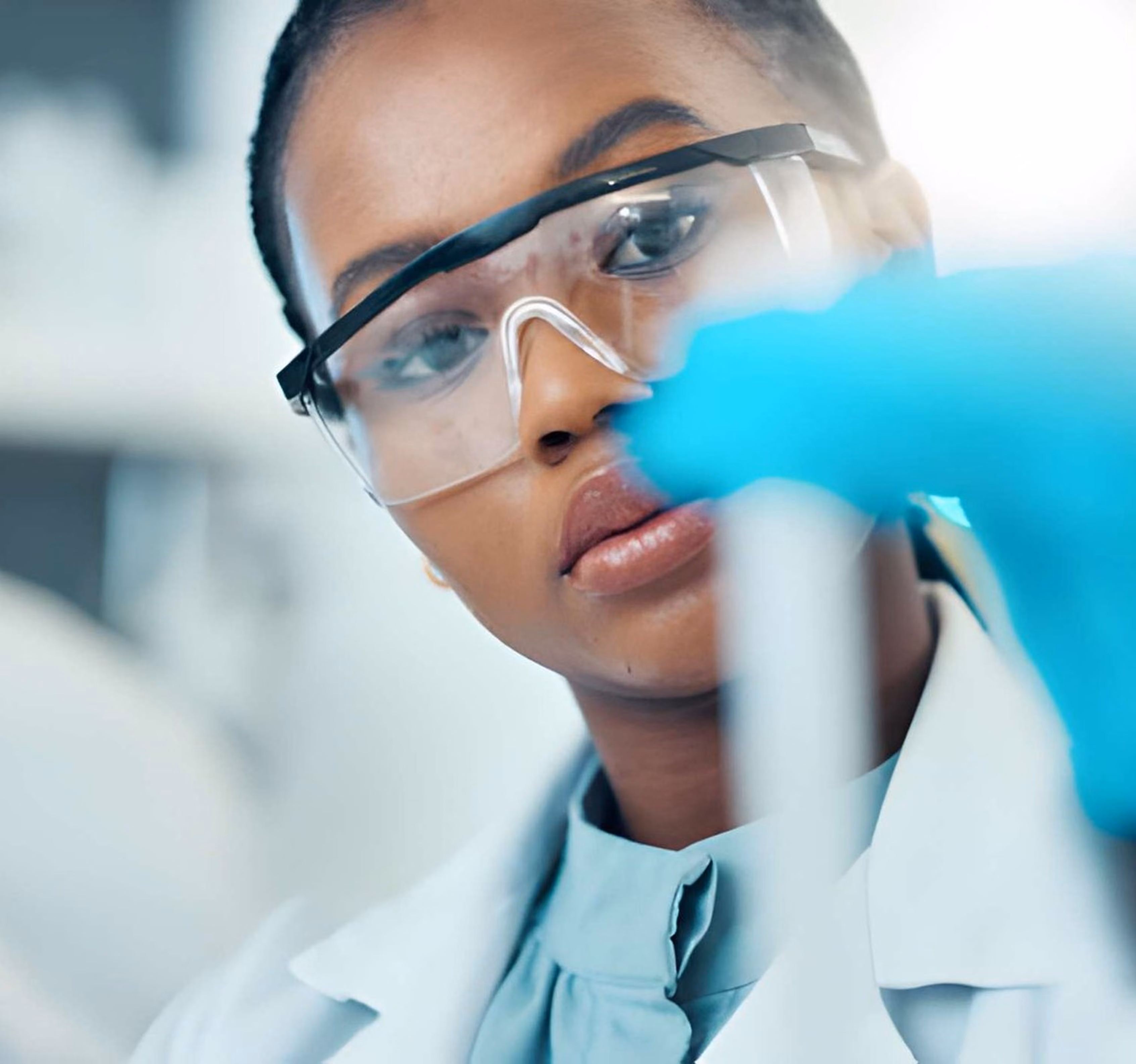 Scientist in safety glasses conducting a lab test, representing healthcare and medical technology