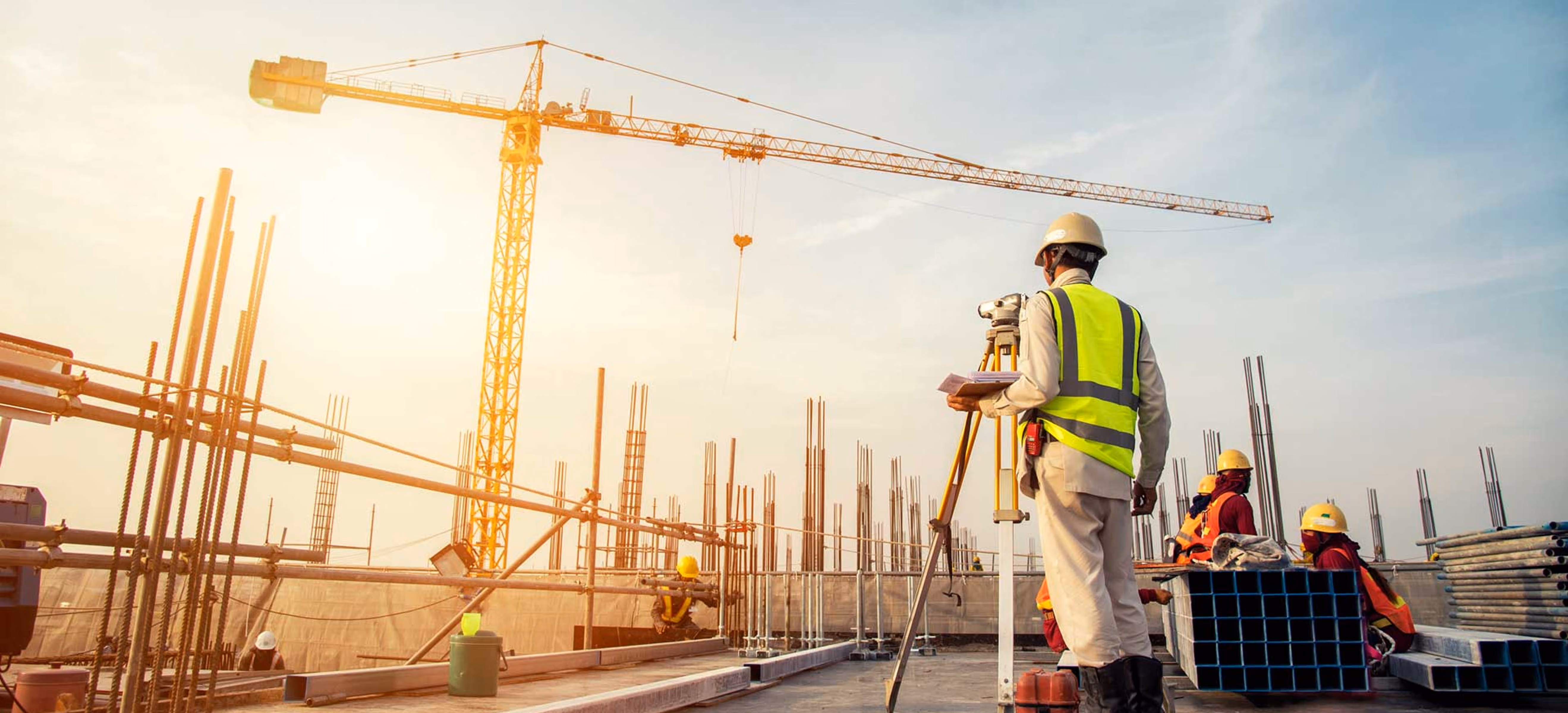  Construction worker surveying a building site with a crane, representing real estate and development