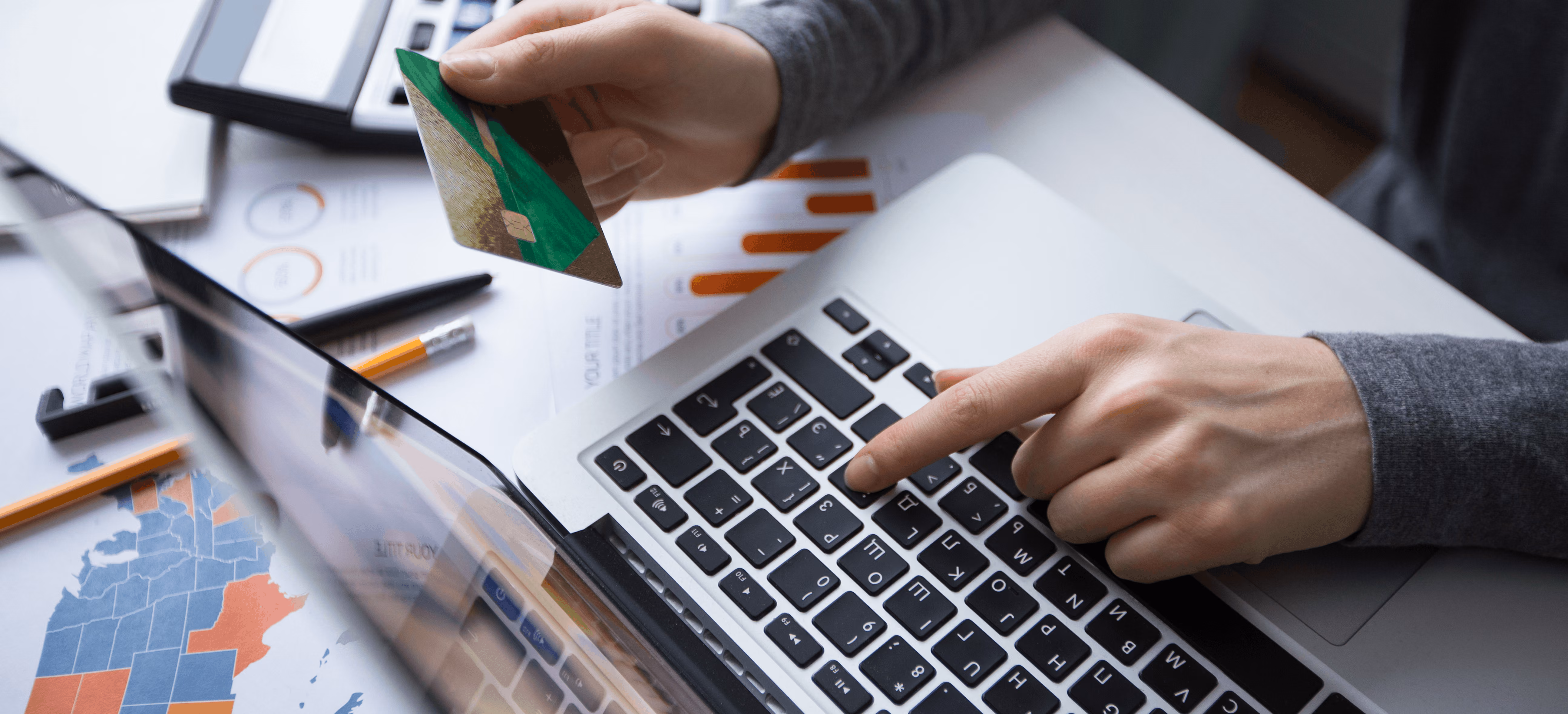 Person making an online payment with a credit card and laptop, representing consumer retail industry