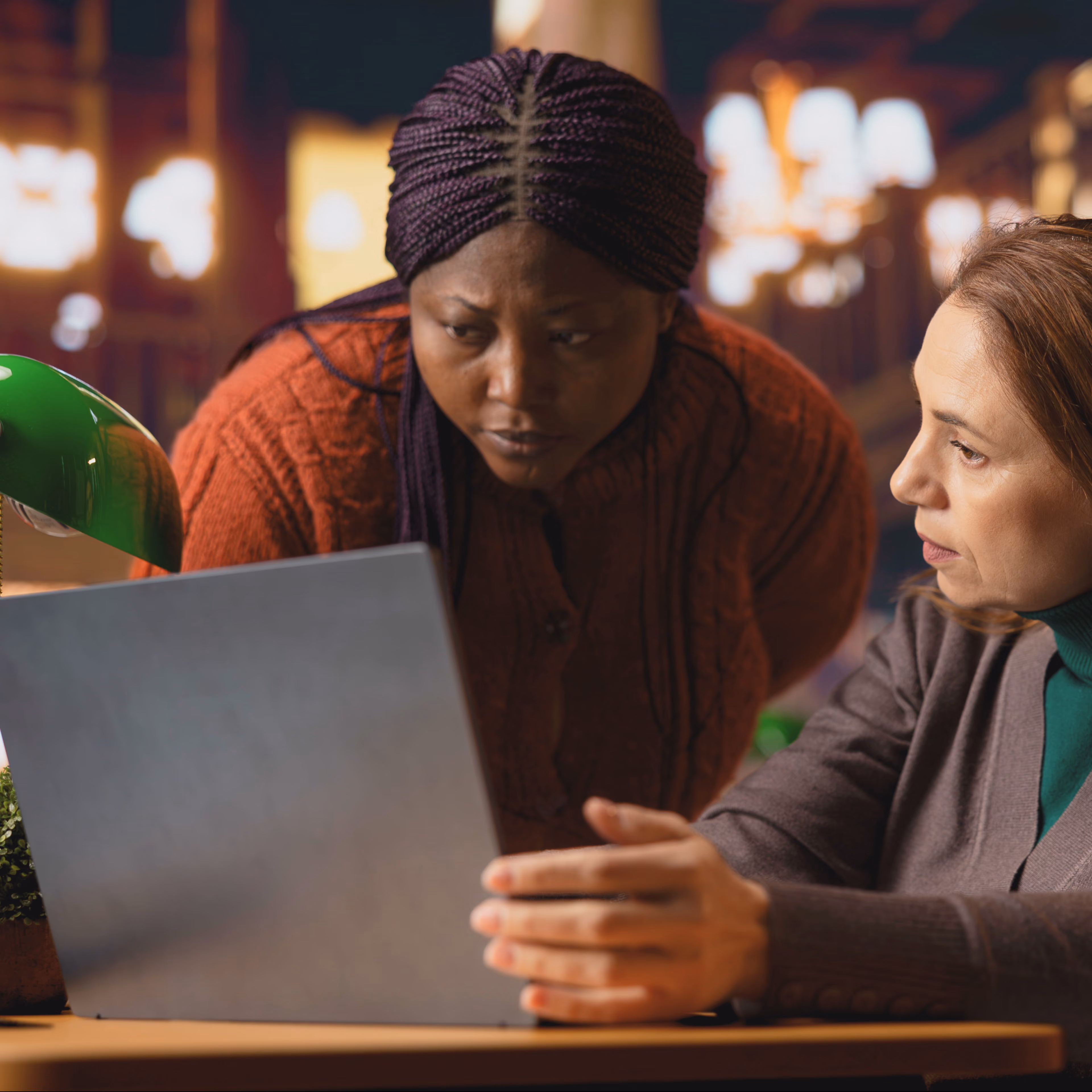 Two professionals reviewing data together on a laptop to analyze audience insights and improve strategy decisions.