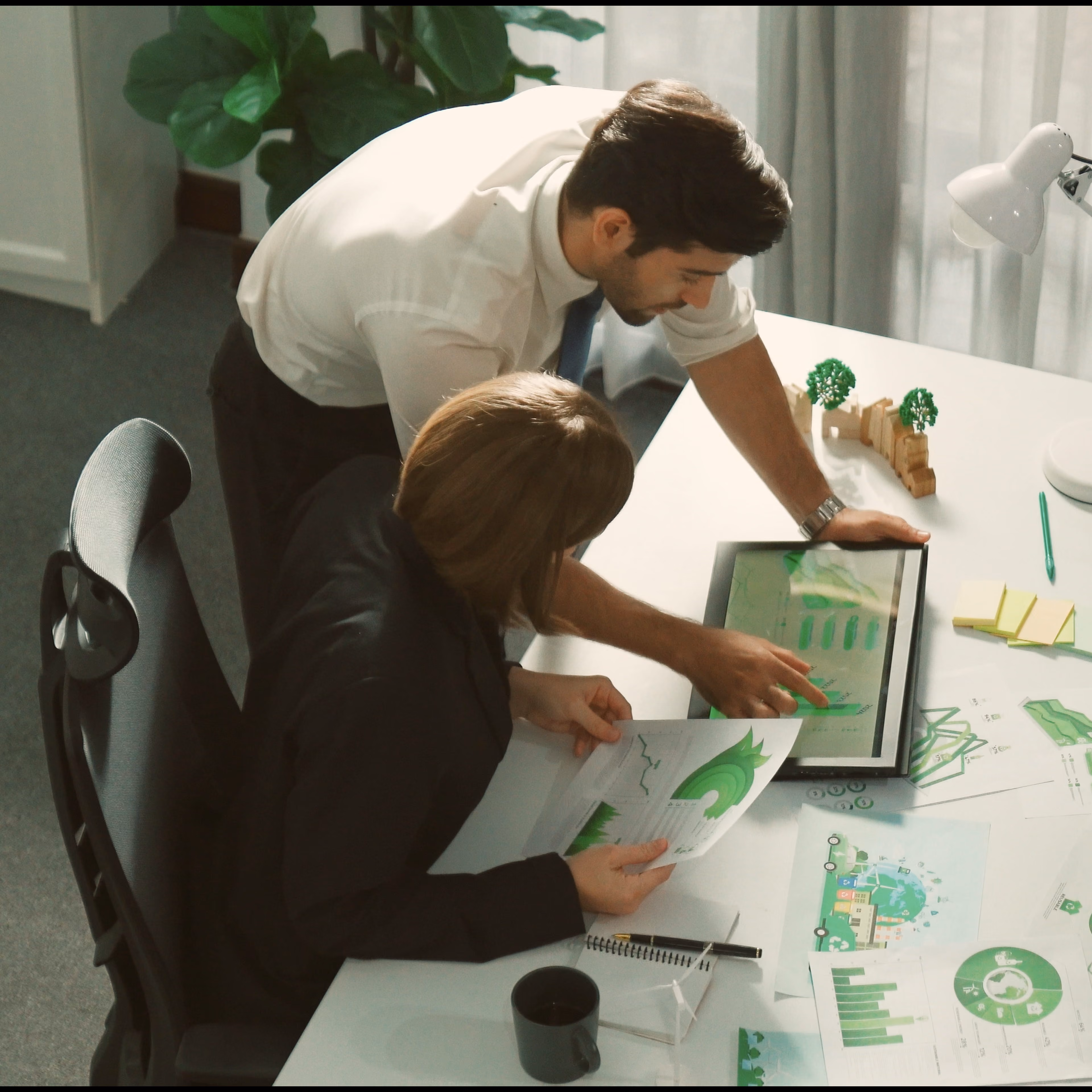 Team reviewing reports and presentation charts to develop a strategic narrative and business communication plan.