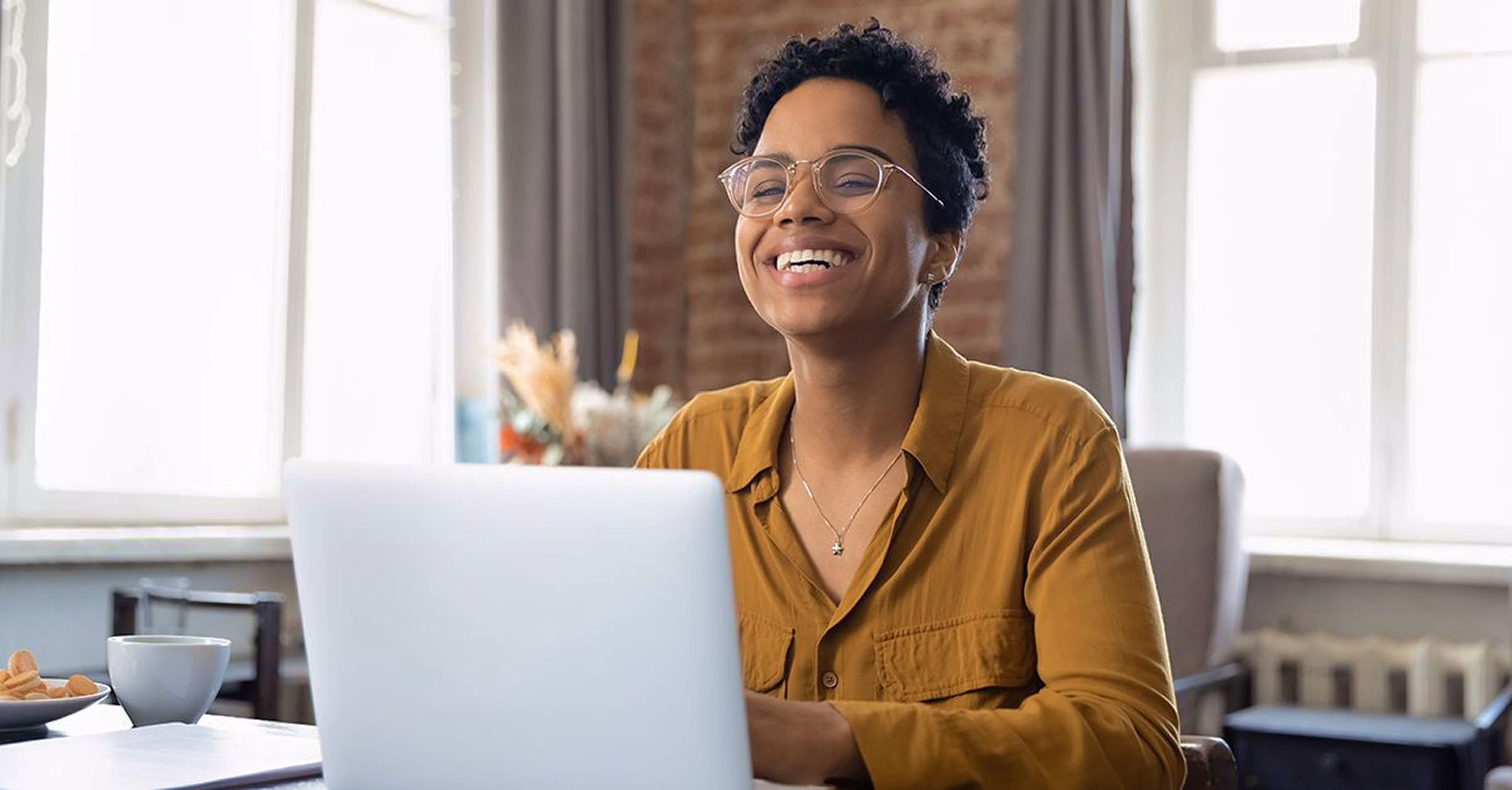 Professional smiling during a virtual meeting on a laptop in a bright office representing retail customer support.
