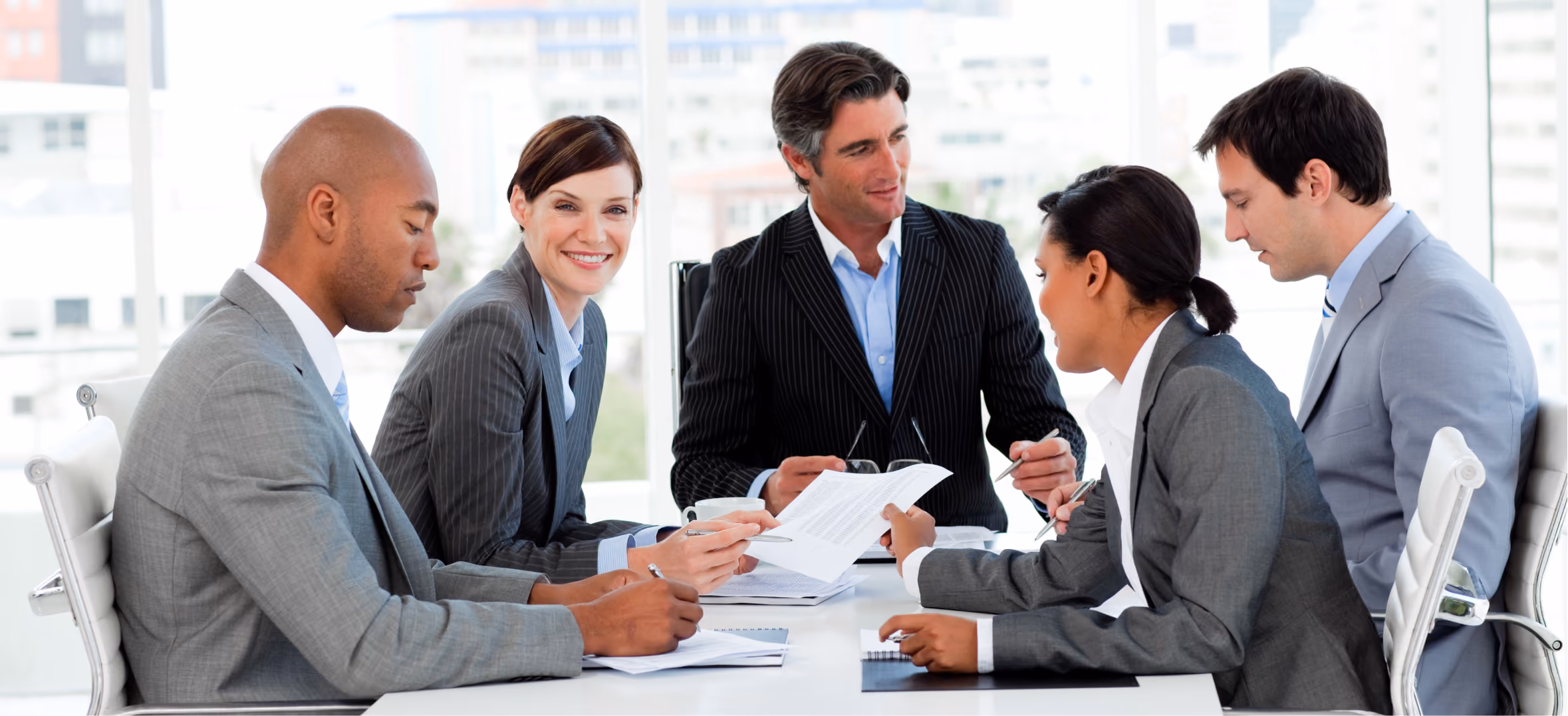 Corporate consultants discuss business strategy and documents during a professional team meeting together.