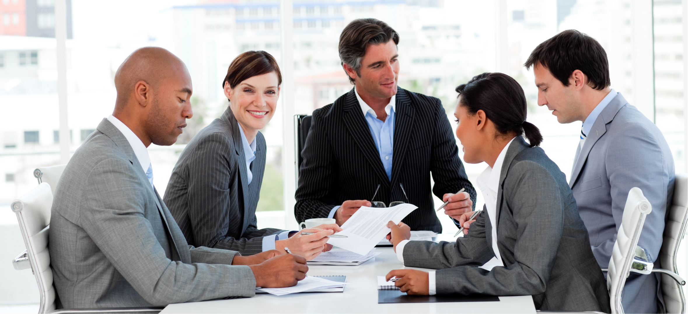 Corporate consultants discuss business strategy and documents during a professional team meeting together.