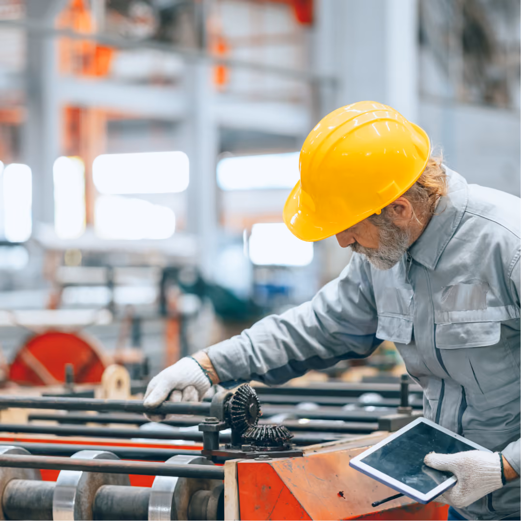  Factory worker inspecting machinery, representing manufacturing and industrial modernization design work here.