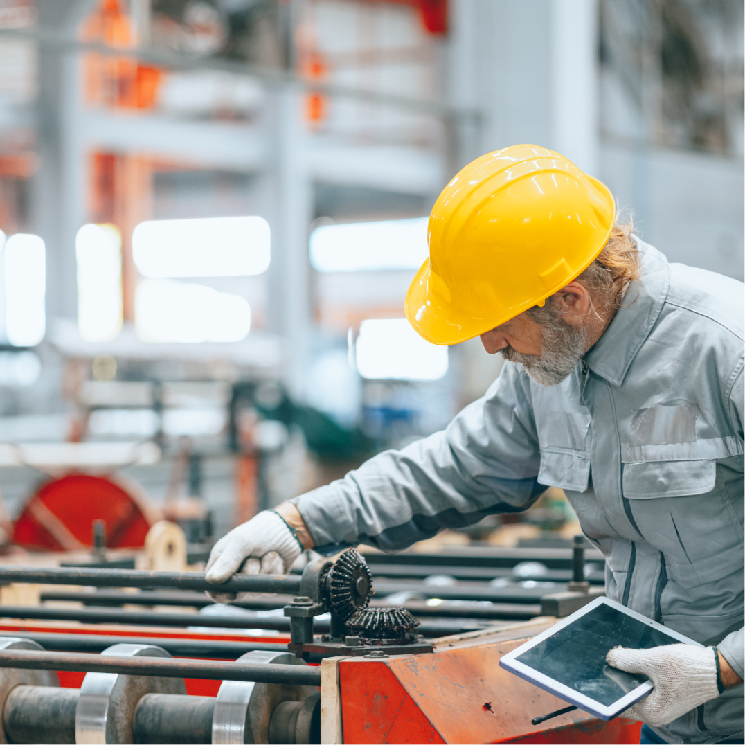 Factory worker inspecting machinery, representing manufacturing and industrial modernization design work here.