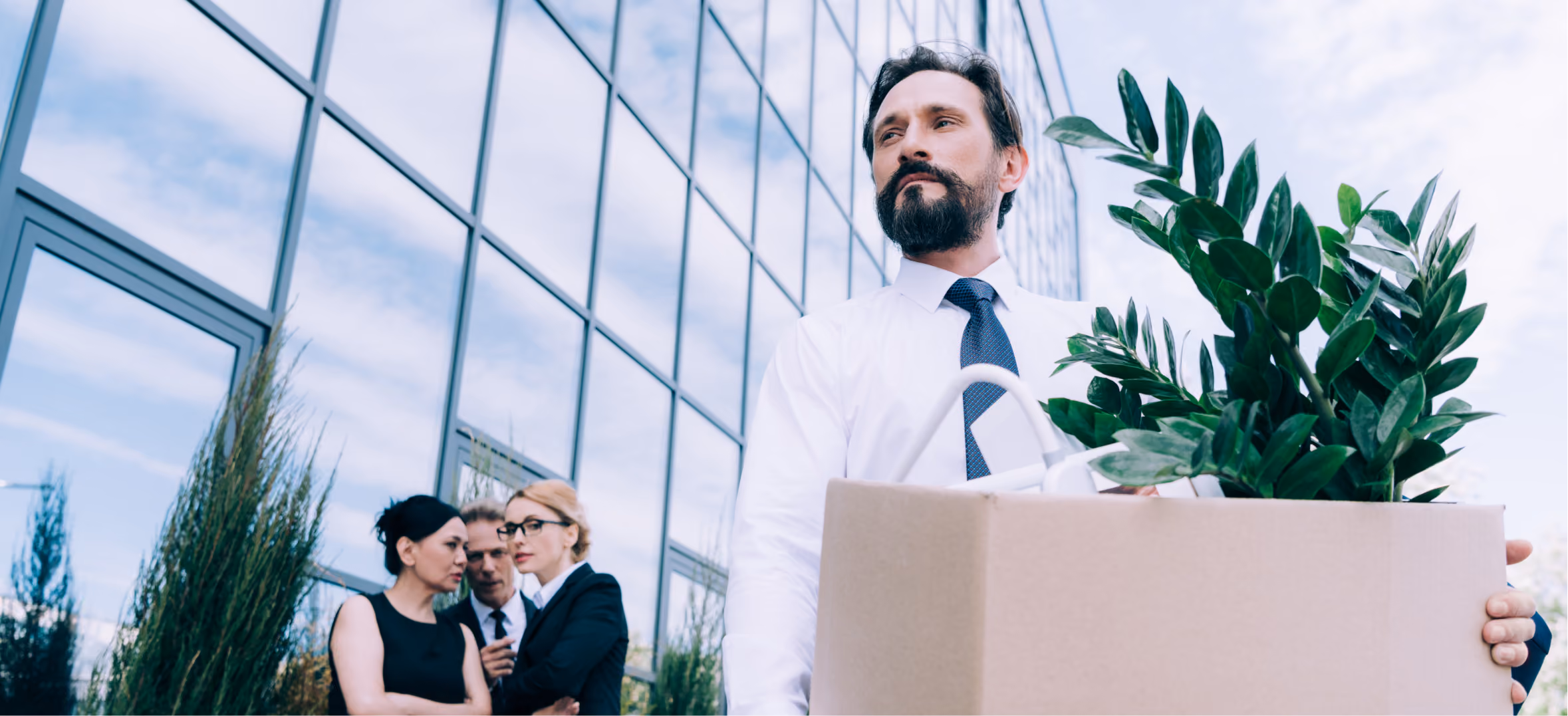 Businessman carrying box, leaving office building, representing corporate relocation and HQ establishment