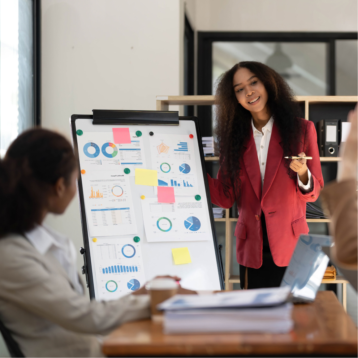 Business presenter explains charts and performance metrics during team strategy meeting using presentation boa