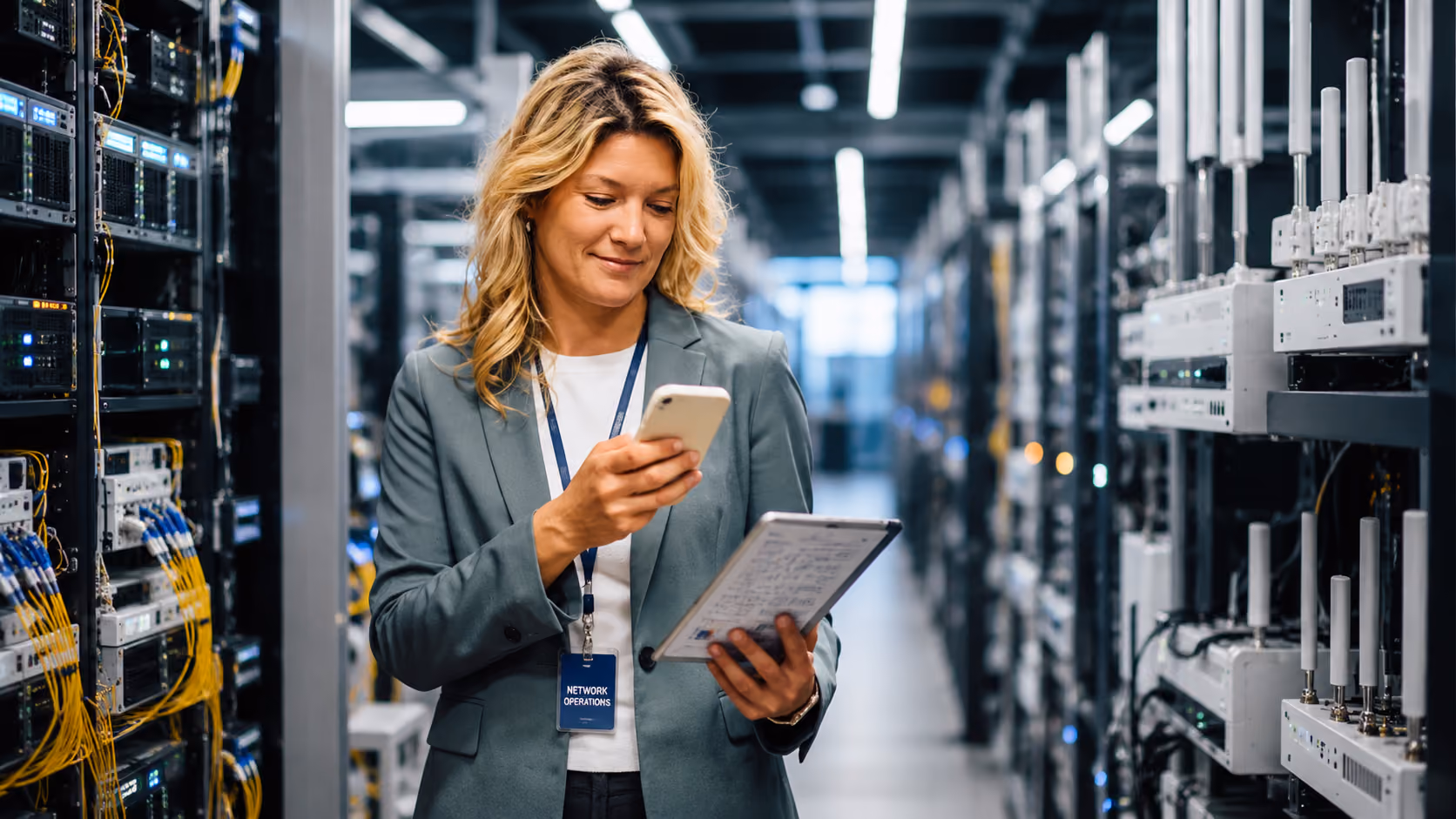 Network operations specialist managing wireless infrastructure with tablet and mobile monitoring systems.