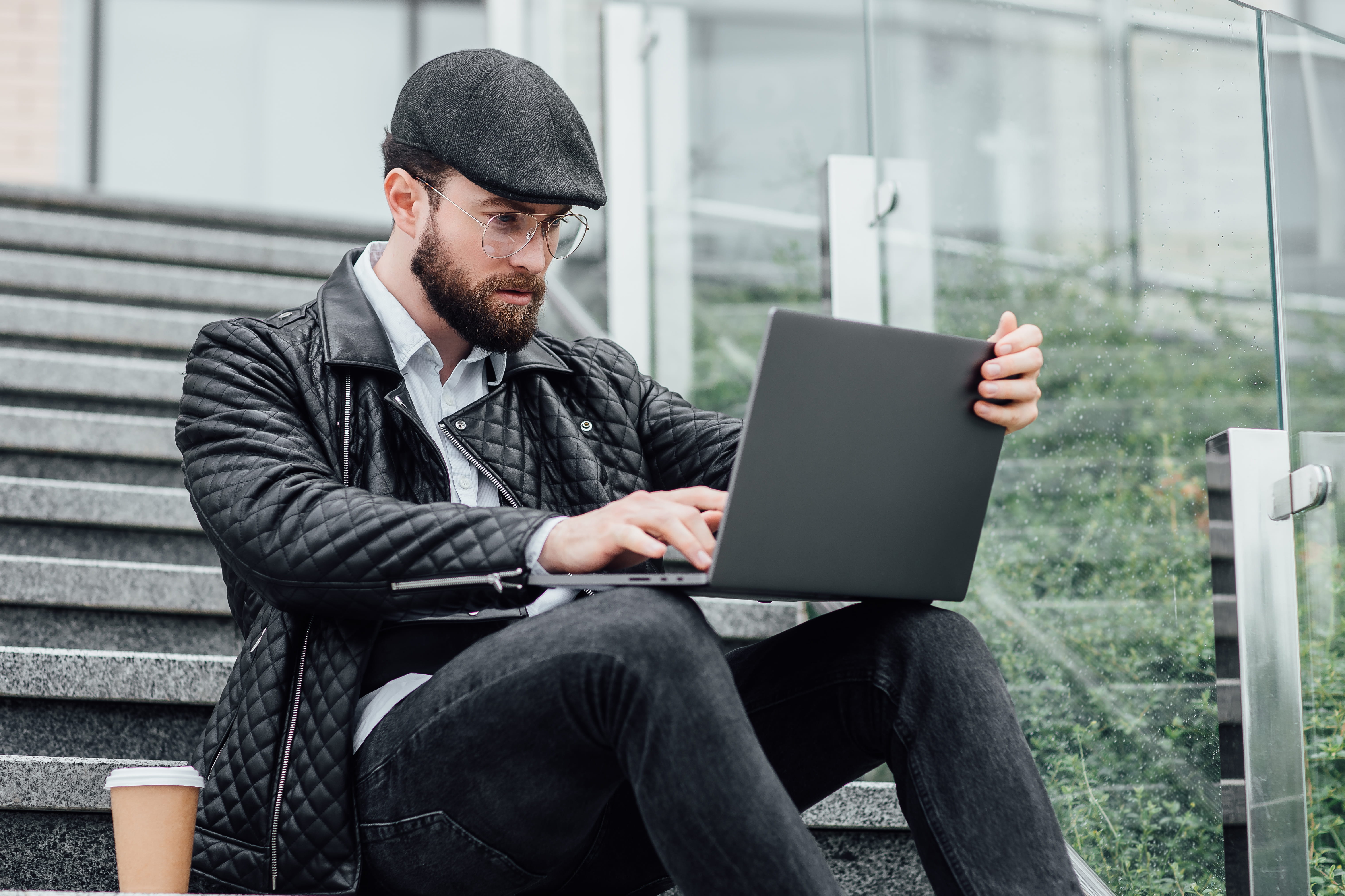Professional on a laptop outdoors, representing digital delivery of board-ready presentation files for review.