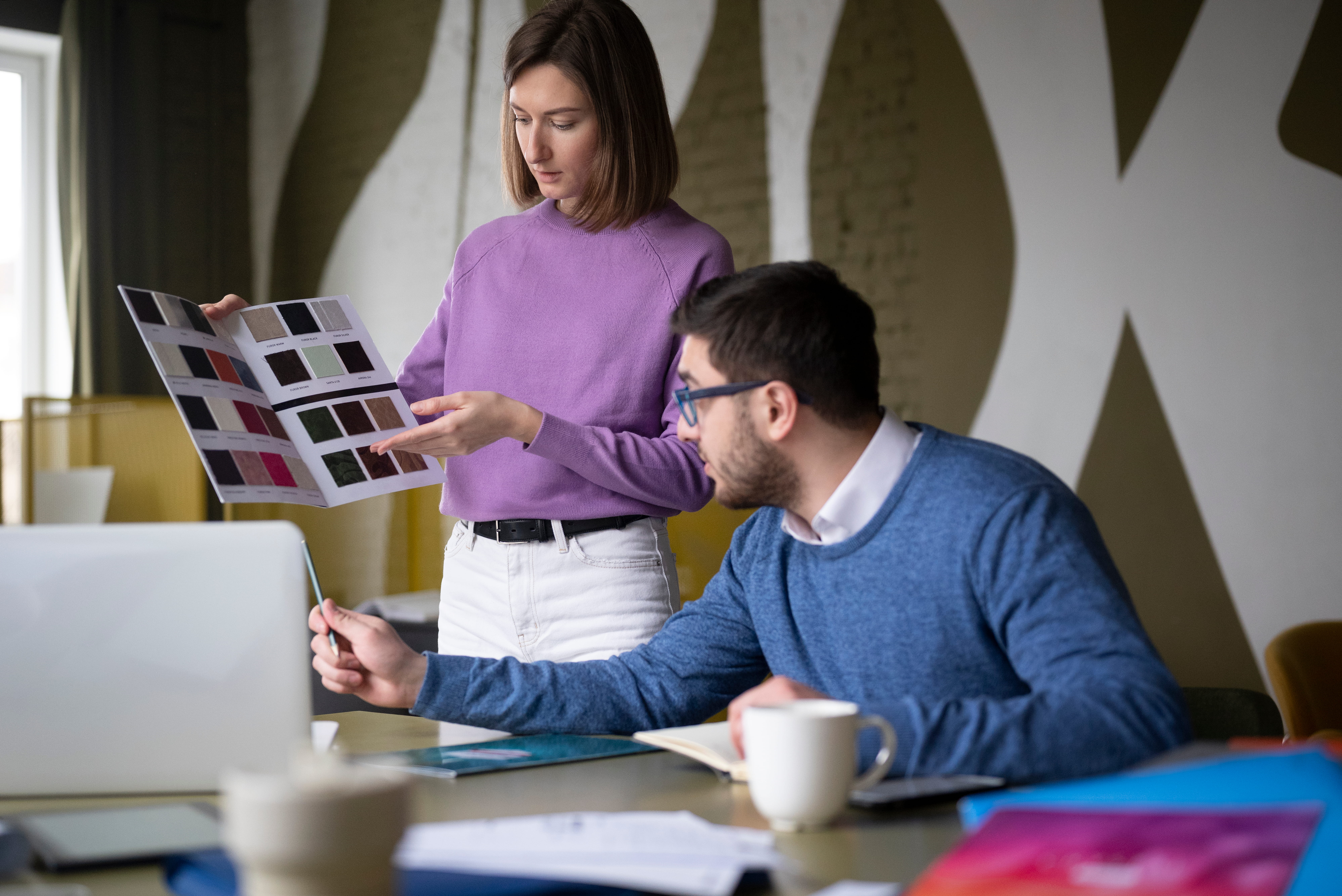 Design team reviewing presentation and layout samples for a polished executive board presentation deck design.