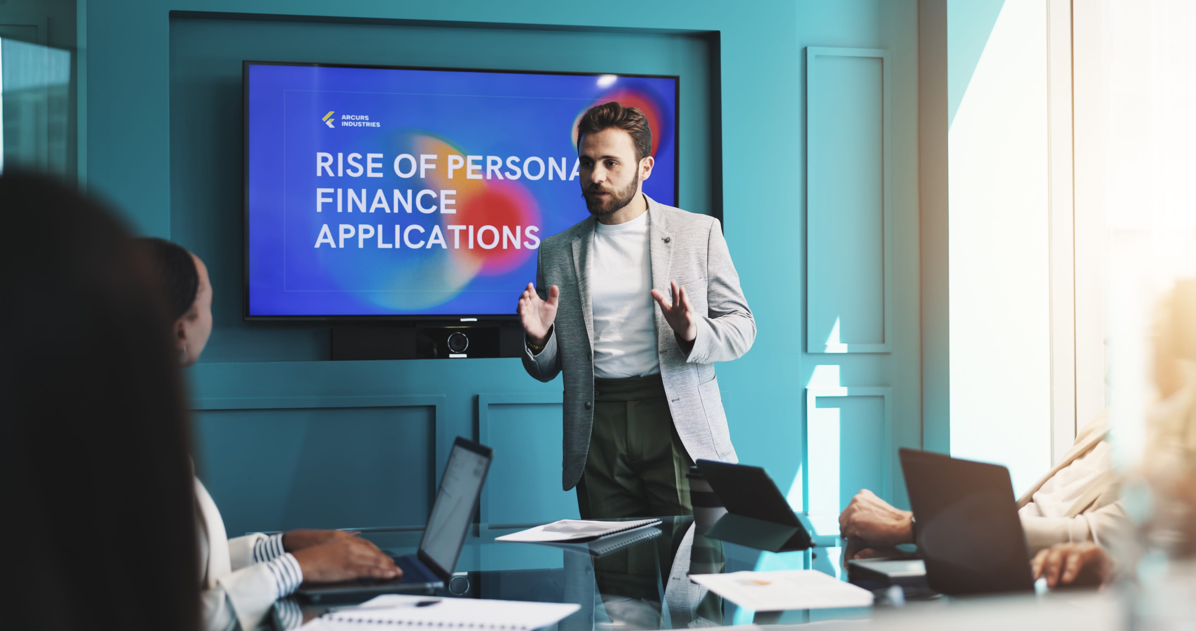 Executive presenting a key finance strategy to a committee using a presentation screen during a board meeting.