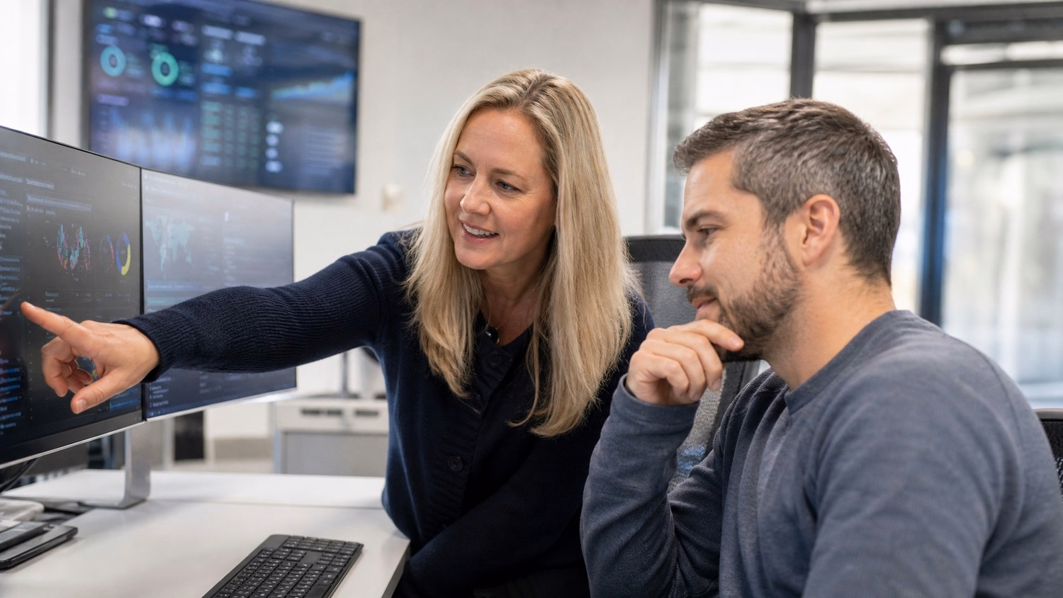 Woman explains cybersecurity dashboard to man