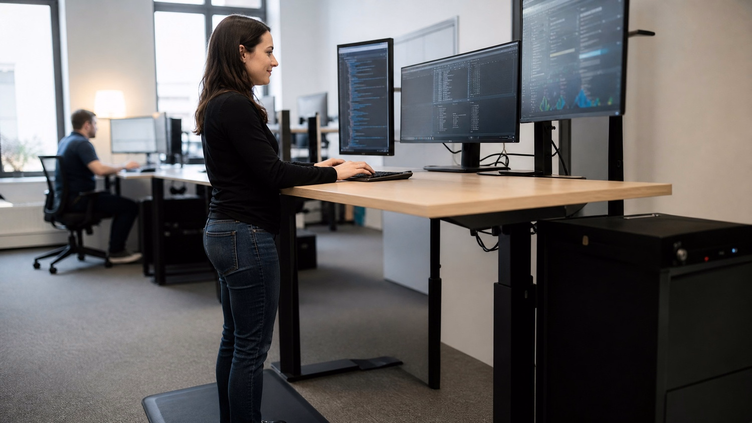 Woman on anti-fatigue mat typing system logs at raised desk