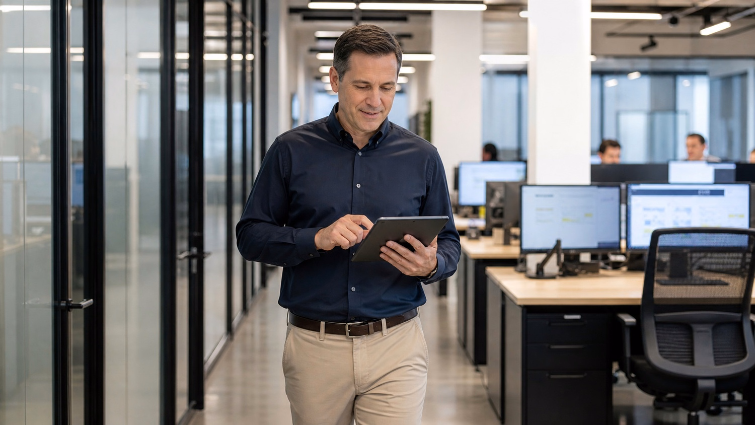 Man reviewing tablet data in bright office corridor 59