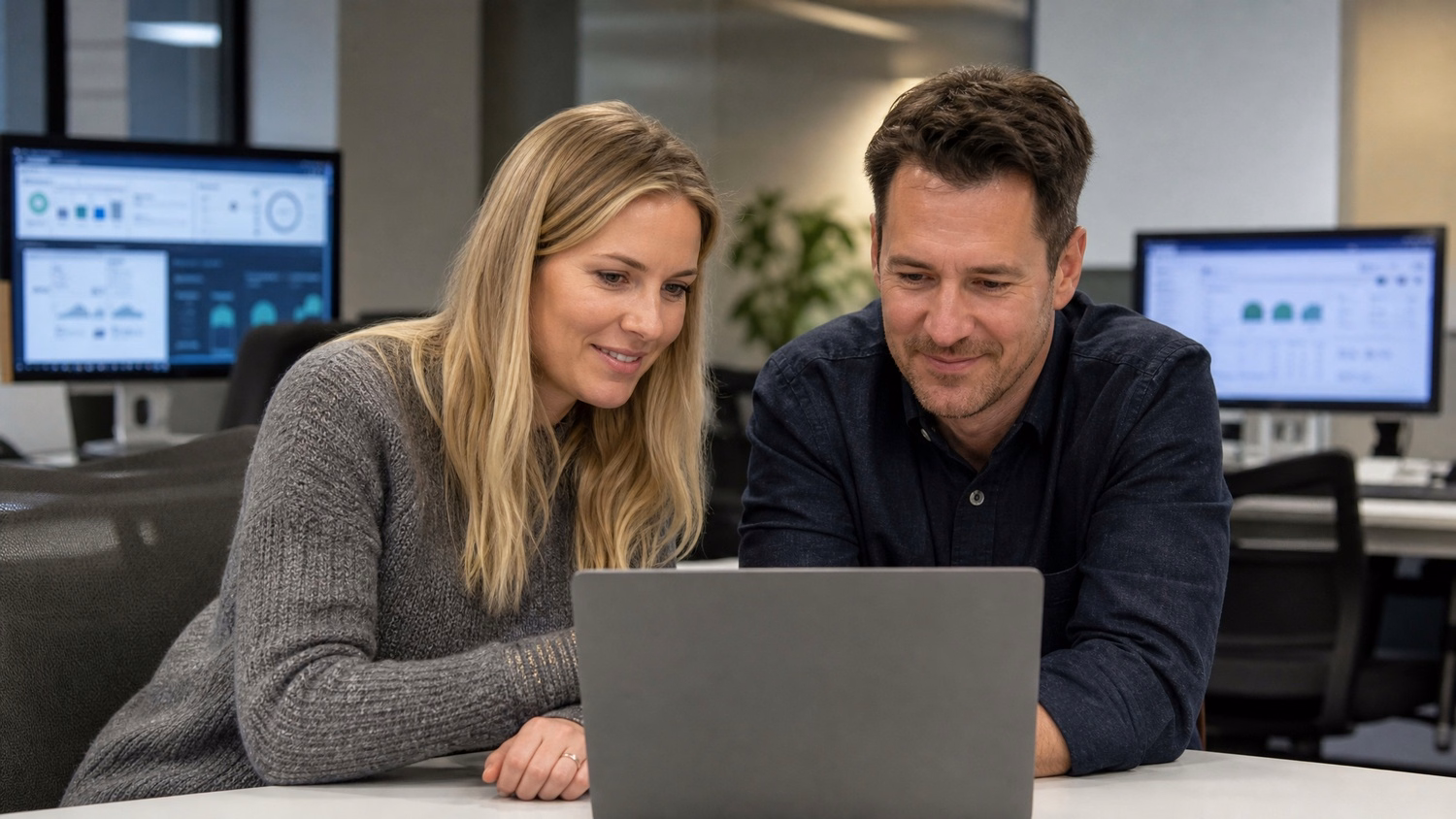 Consultants reviewing laptop screen together at table