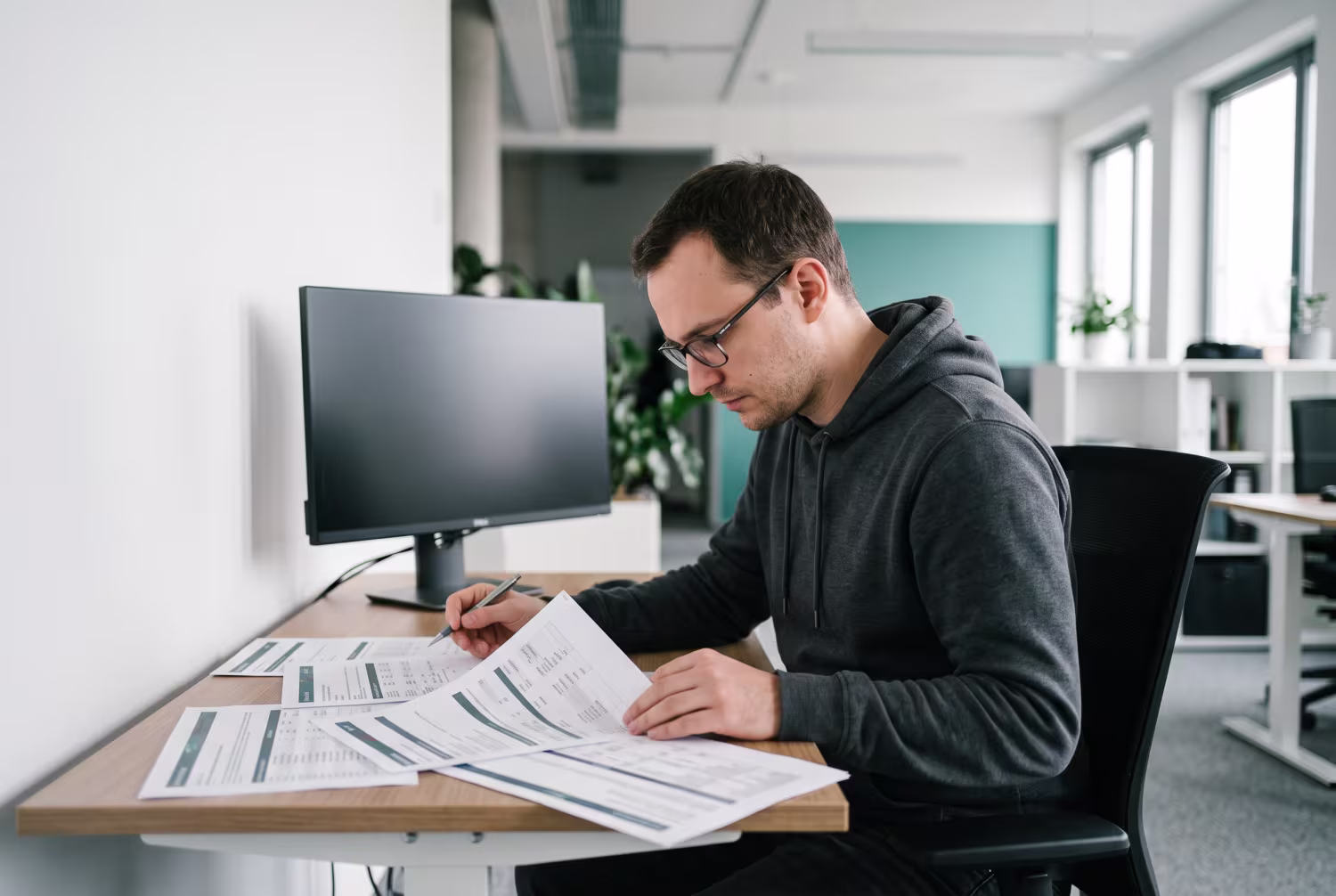 Penetration tester examining printed vulnerability reports in office