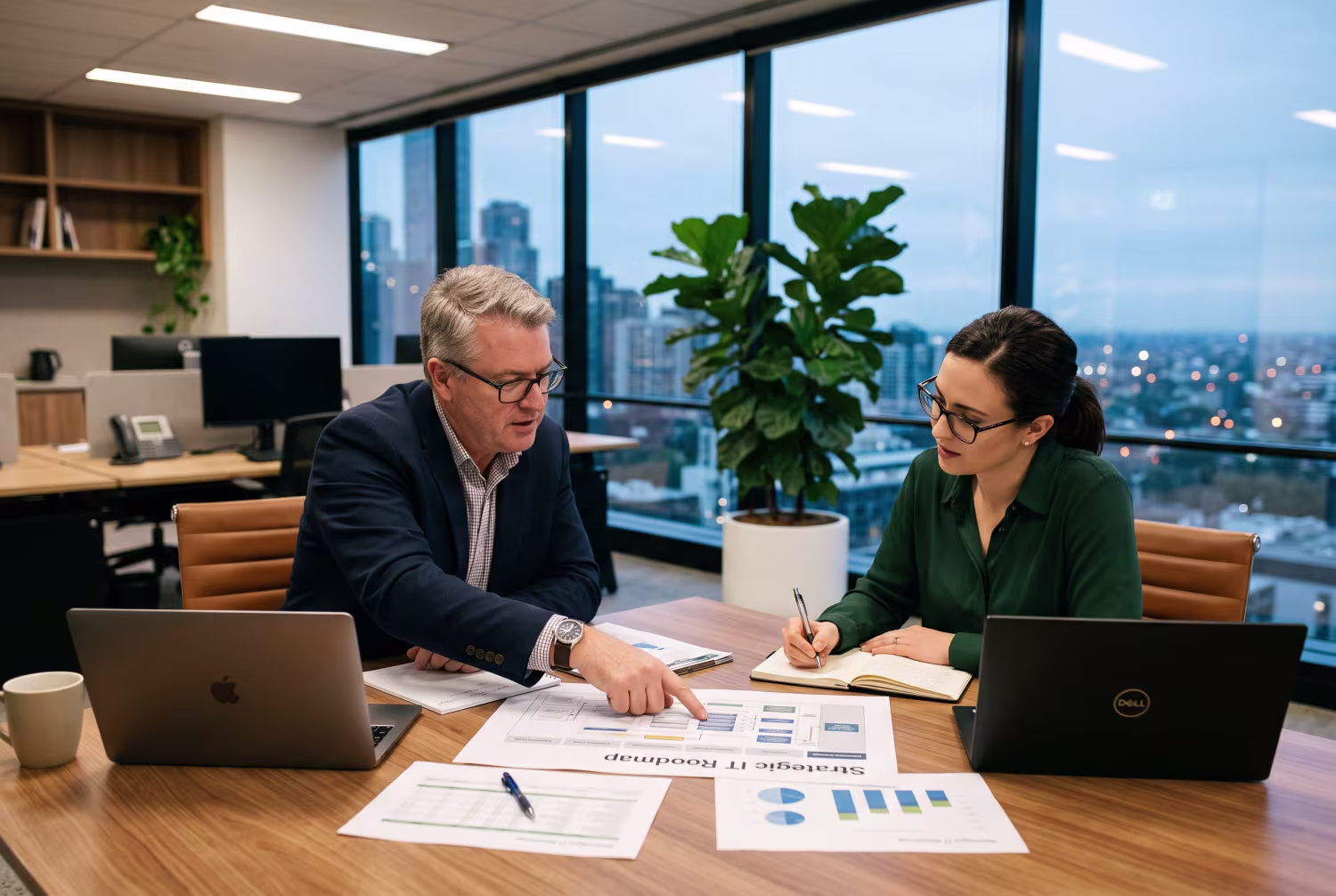 Two IT consultants discussing IT strategy roadmap at office