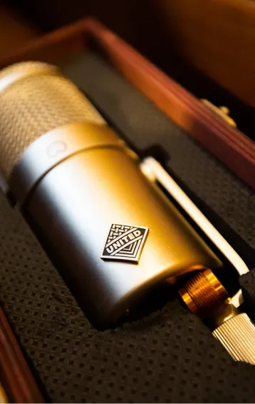 Close-up of a studio microphone with a United logo resting in a protective case.
