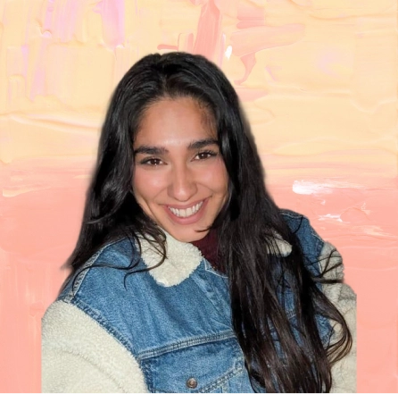 Smiling woman with long dark hair wearing a blue denim jacket with white fleece lining.