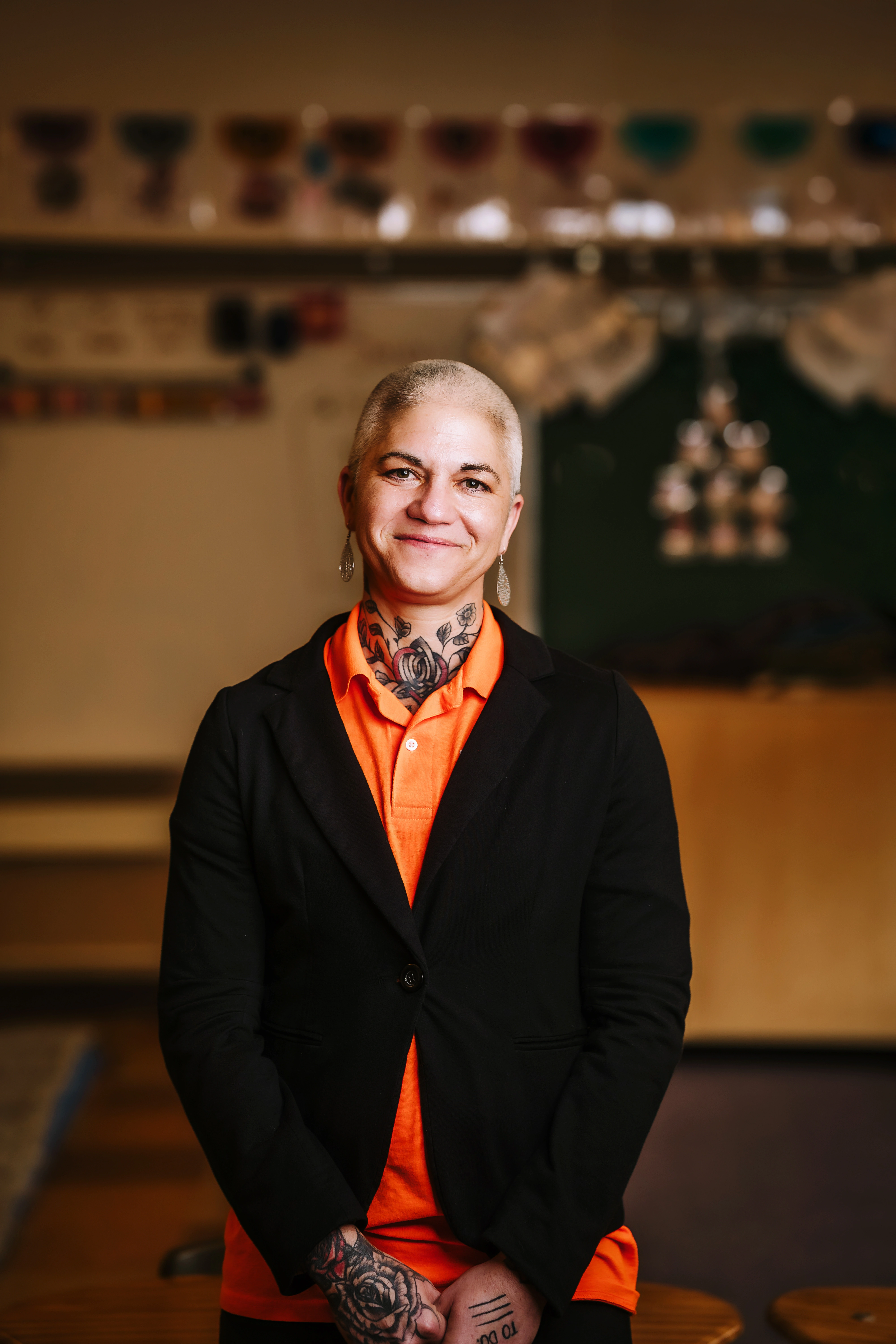 Jessica Vorster smiling in a black blazer and orange shirt