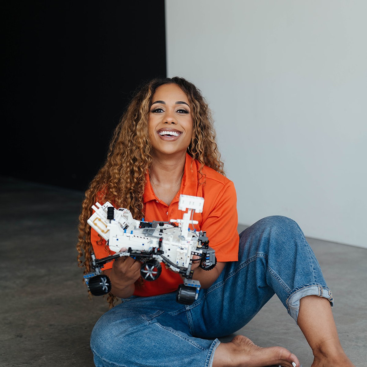 Dr. Arielle Hammond, founder and CEO of enrops, holding a LEGO rover build