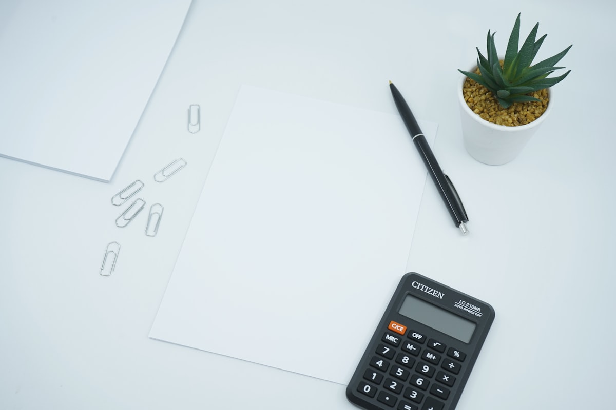 Calculatrice et stylo posés sur un document, illustrant le calcul de la retraite avec majoration enfants