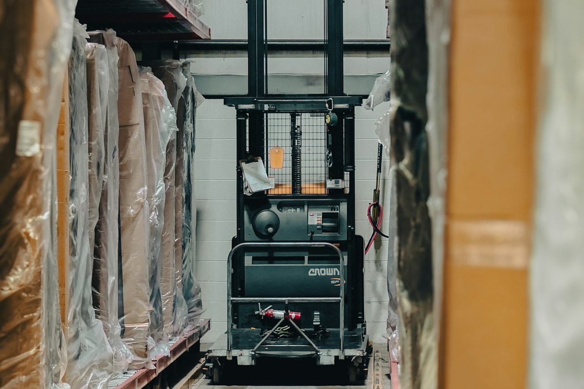 Convention collective applicable : entrepôt logistique avec chariot élévateur et rayonnages de marchandises
