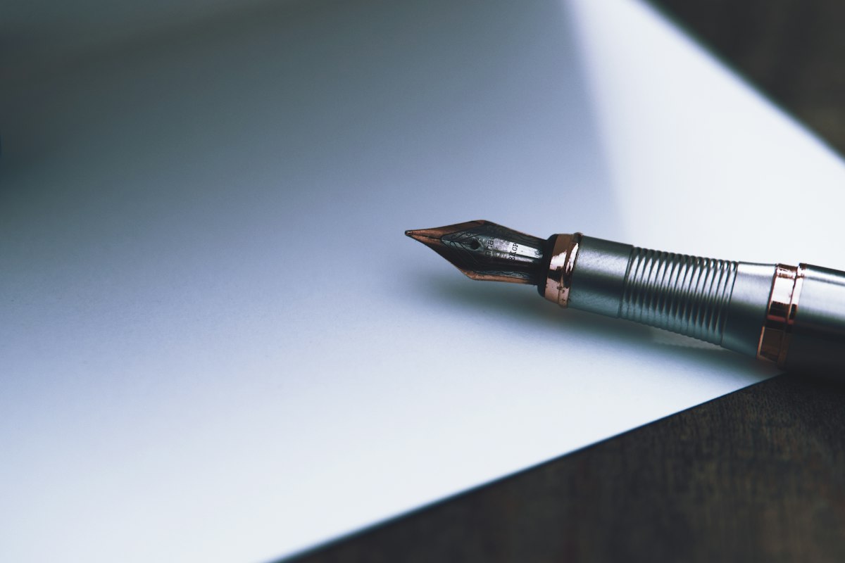 Stylo plume posé sur une feuille, symbole de l'accord signé ouvrant droit à l'indemnité forfaitaire de conciliation exonérée de cotisations