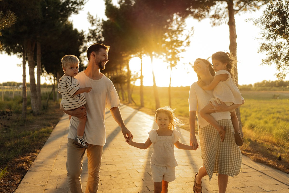Prévoyance obligatoire des cadres : famille marchant main dans la main au coucher du soleil