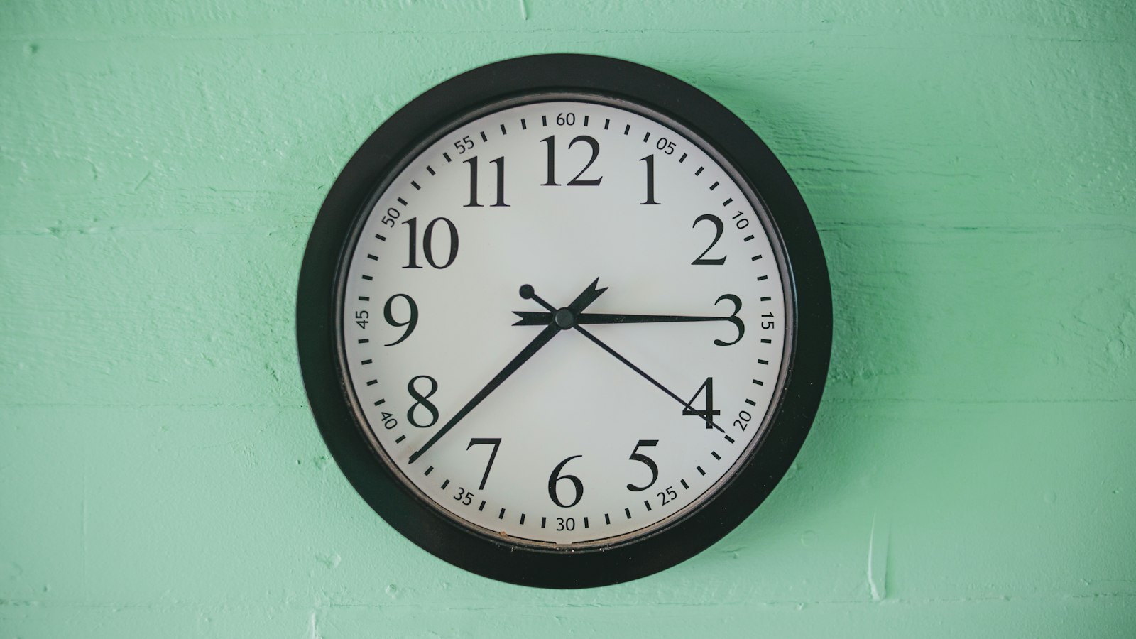 Horloge murale ronde sur un mur vert pâle : durée du travail des personnels des établissements scolaires OGEC