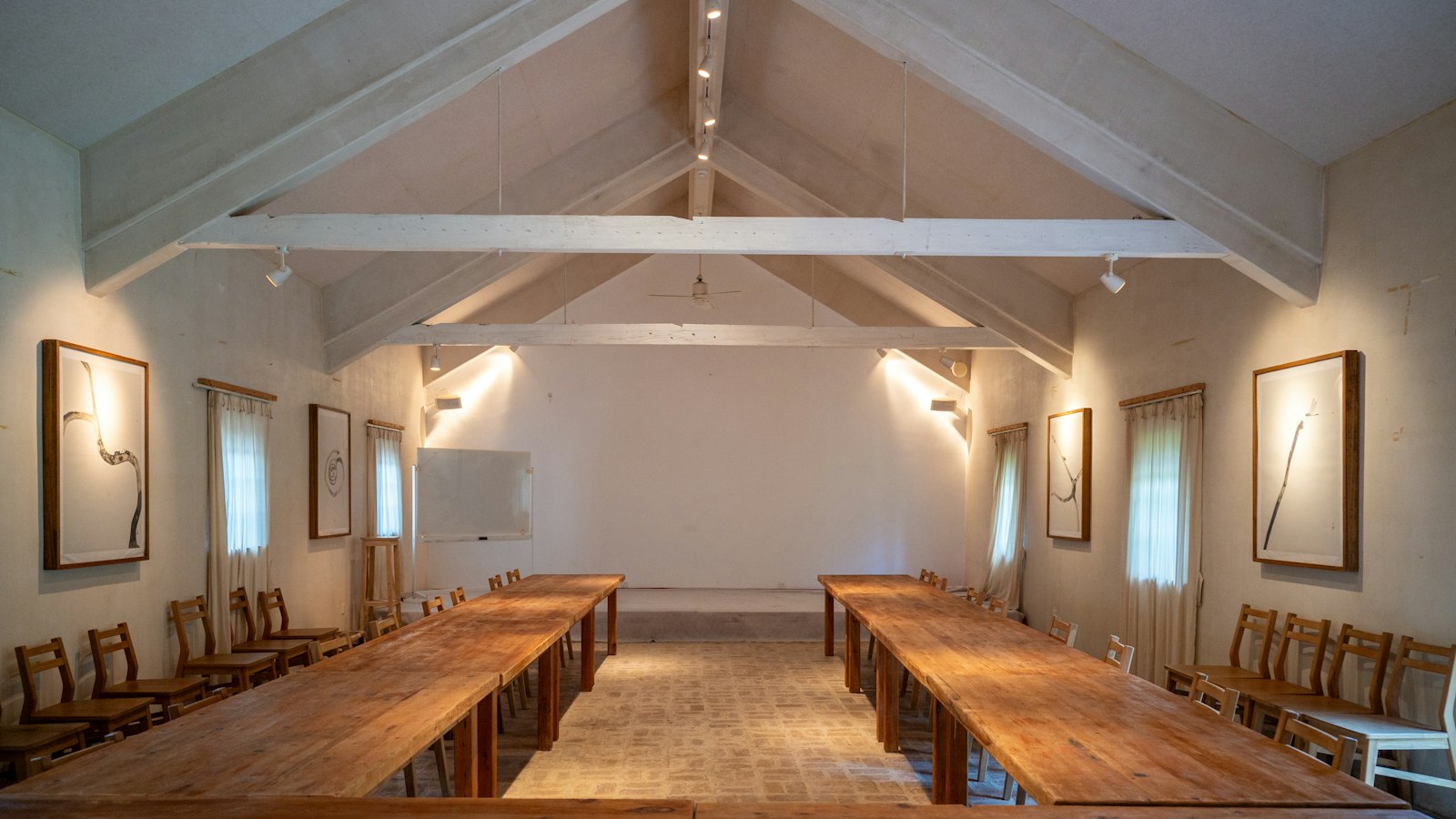 Salle de réunion sous charpente, tables en bois disposées en U : représentation du personnel et CSE en OGEC