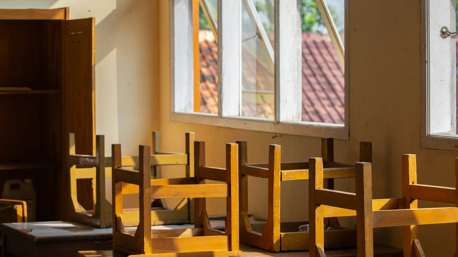 Salle de classe en fin de journée, chaises retournées sur les tables : rupture du contrat de travail en OGEC