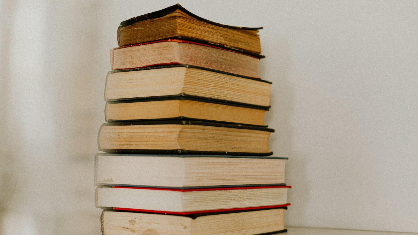 Pile de livres anciens sur fond clair : champ d'application de la convention collective EPNL, enseignement privé