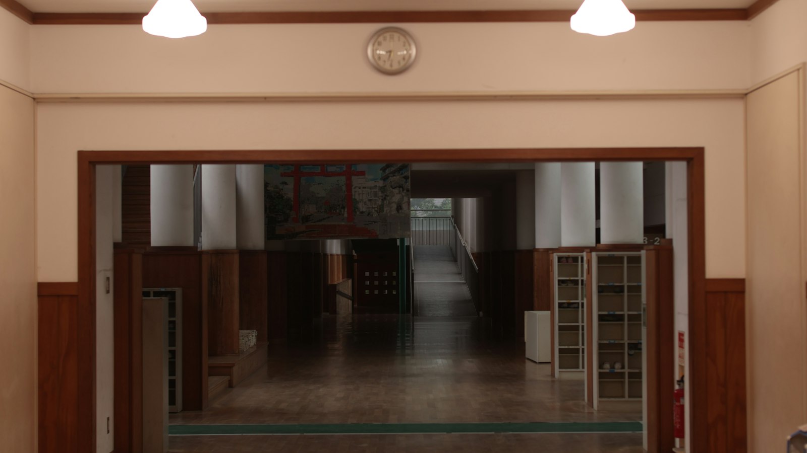 Hall d'une école ancienne, lambris et horloge murale : personnels d'éducation et de vie scolaire de l'OGEC