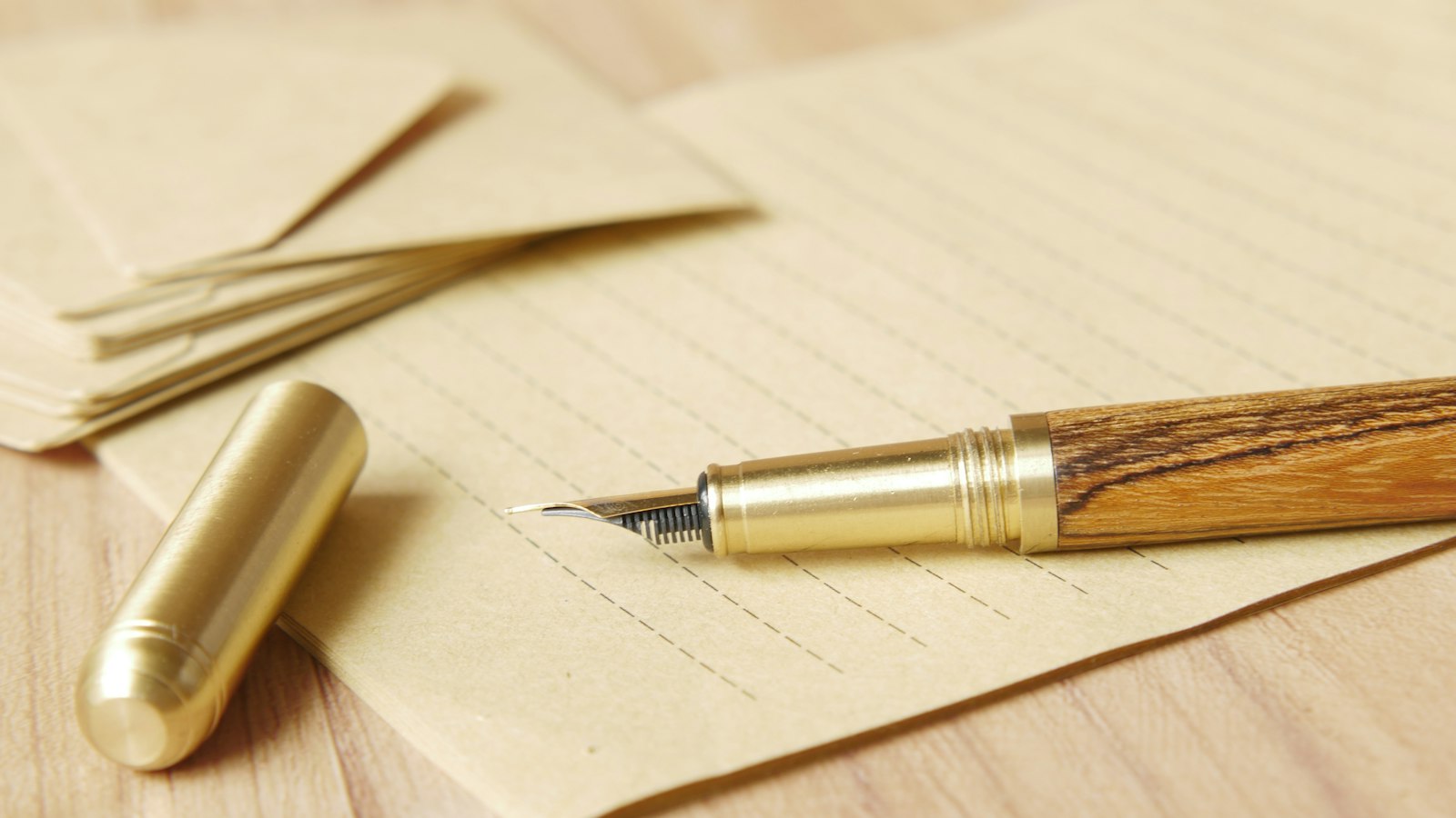 Stylo plume sur du papier à lettres kraft, enveloppes à côté : contrat et lettre de mission du chef d'établissement
