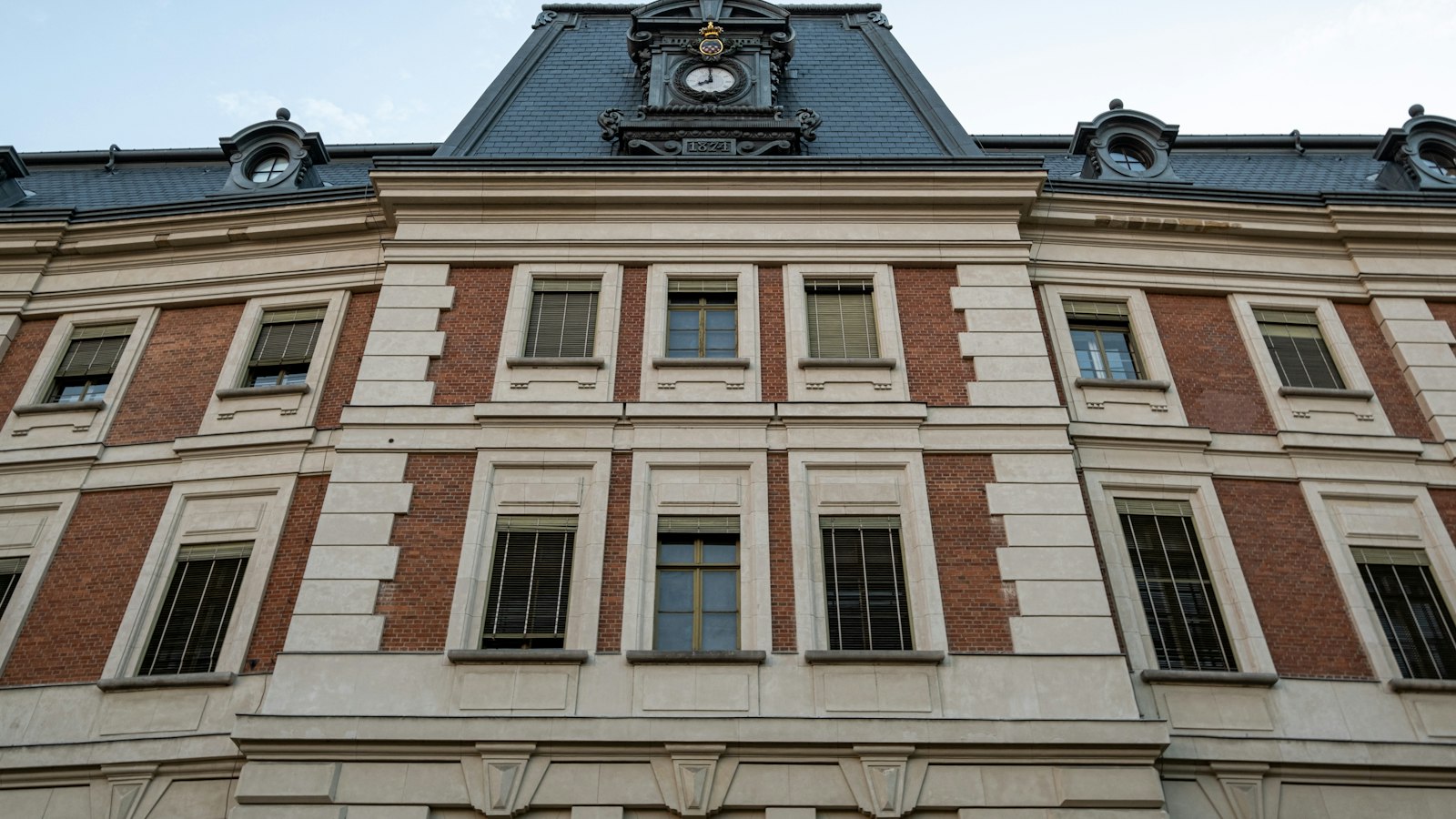 Façade en brique et pierre, toit d'ardoise et lucarne à horloge : contrat d'association et contrat simple avec l'État