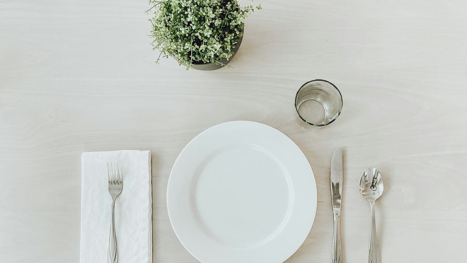 Couvert dressé sur une table blanche : les avantages en nature accordés au personnel de l'OGEC