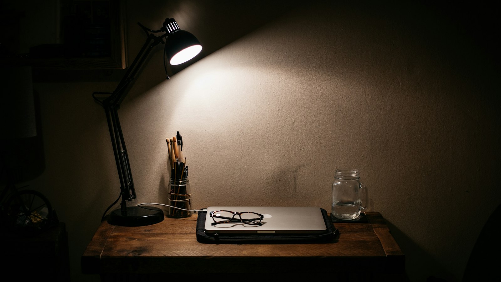 Lampe de bureau allumée sur une table en bois : les cadres de l'OGEC et leur statut conventionnel