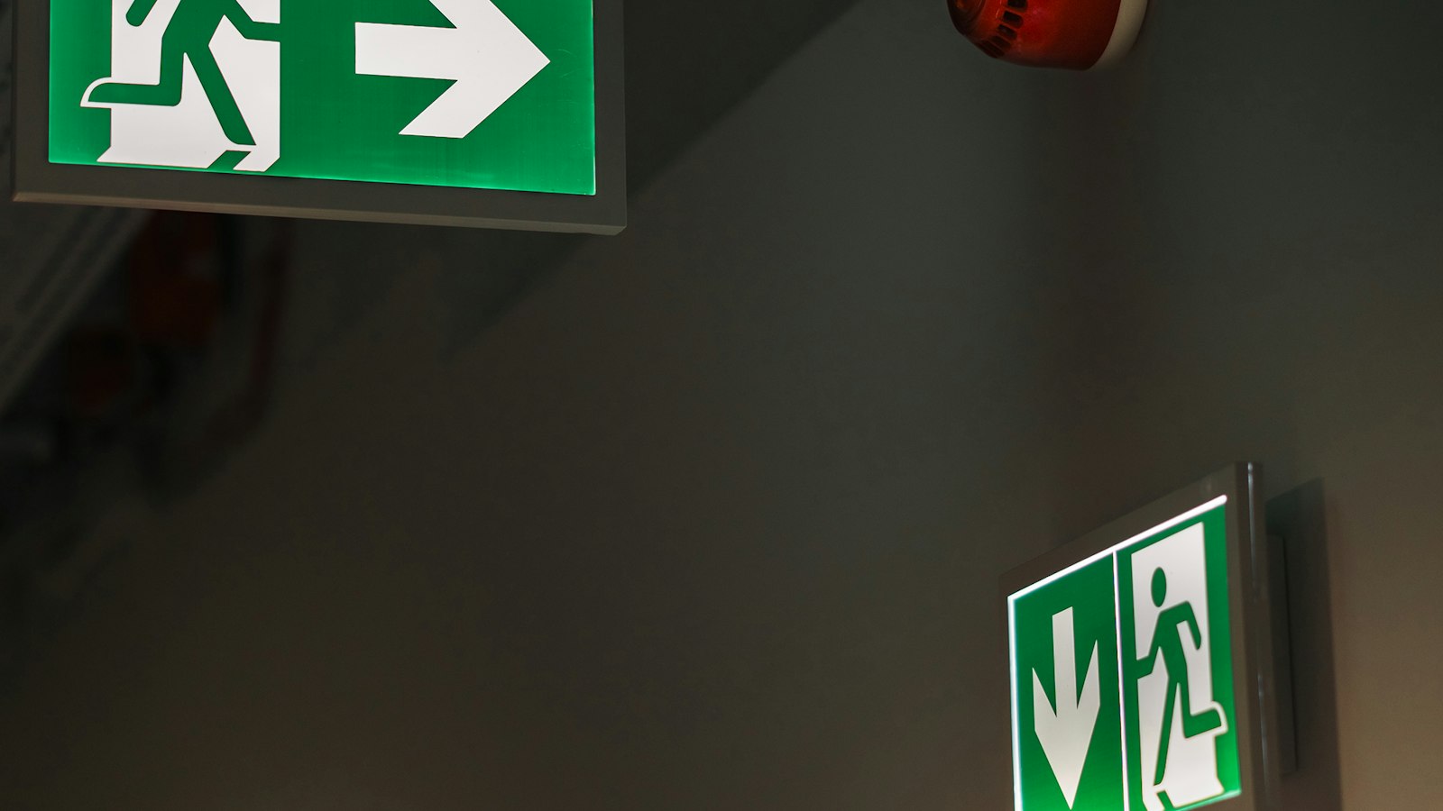 Pictogrammes verts de sortie de secours dans un couloir : évaluation des risques et document unique de l'établissement scolaire