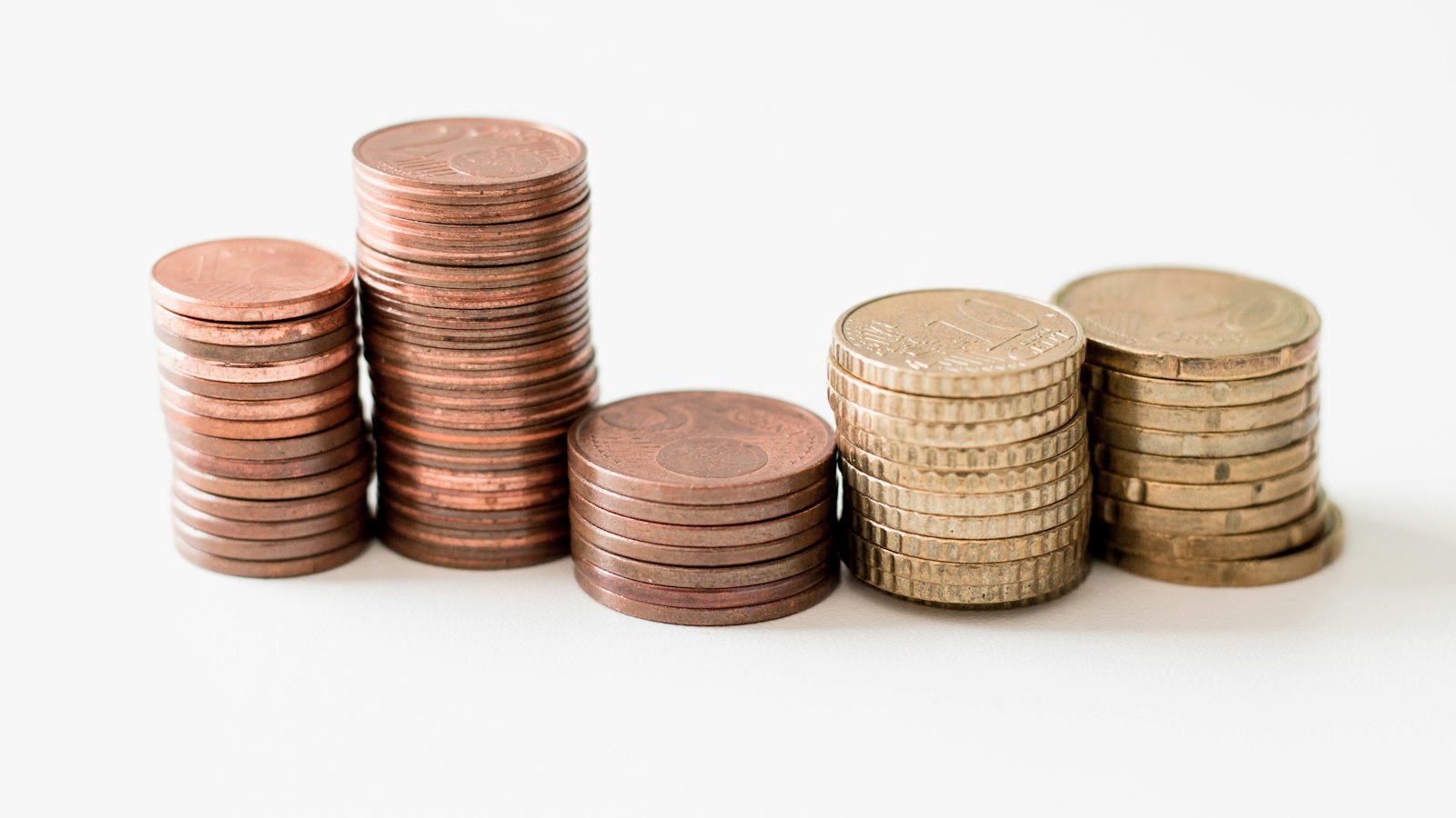 Piles de pièces de monnaie sur fond blanc : les indemnités de rupture du salarié de l'OGEC