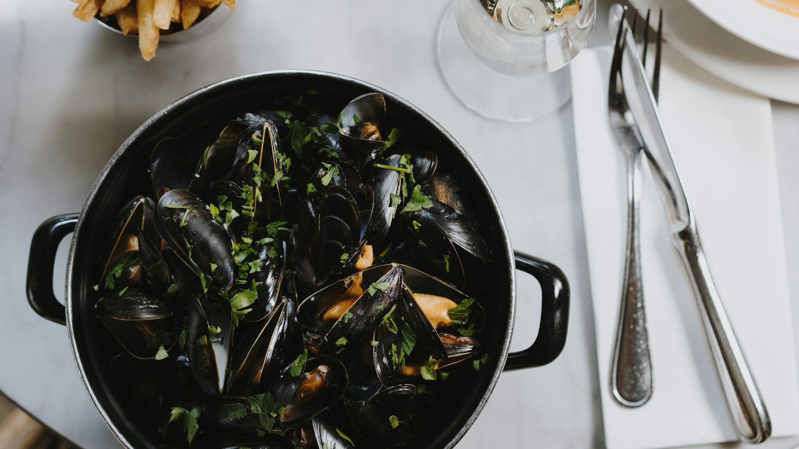Cocotte de moules et frites sur une table de bistrot : l'avantage en nature nourriture en HCR